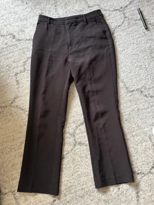 Svarta raka kostymbyxor - Snygga svarta kostymbyxor med raka ben och pressveck. Byxorna har hällor för skärp och klassisk midja. Perfekta för en clean och stilren look. 