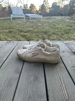 Saint Laurent Skor - Säljer dessa feta Saint Laurent skor i vitt tyg/canvas och slitna detaljer! Storlek 43 1/2, ca 27cm på insidan. Självklart äkta! Sulan har släppt på vissa ställen men inget som syns! Nypris på dessa är 7265kr! Hör av vid funderingar eller frågor!🍾💯🙌🏼
