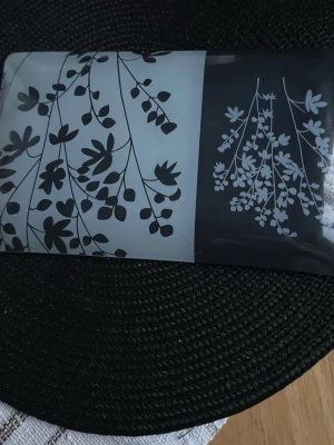 Rektangulärt fat med blommönster - Snyggt rektangulärt fat i glas med svart och vitt blommönster. Fatet har en delad design där ena halvan är vit med svarta blommor och andra halvan är svart med vita blommor. Perfekt som dekoration eller serveringsfat.