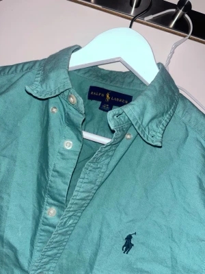 Grön skjorta från Ralph Lauren - Snygg grön skjorta från Ralph Lauren, 100% äkta och knappt använd 158-164 passar den 
