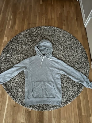 Grå hoodie från polo Ralph lauren! - Säljer en klassisk grå hoodie från Polo Ralph Lauren med vit dragsko i huvan och en stor magficka. Liten broderad logga på bröstet. Perfekt för chill dagar och enkel att matcha med jeans eller joggers.