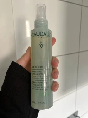 Caudalie Vinoclean rengöringsolja - Caudalie Vinoclean Makeup Removing Cleansing Oil är en genomskinlig rengöringsolja i plastflaska med pump. Innehåller ricin- och sötmandelolja och passar alla hudtyper. Flaskan rymmer 150 ml och har en stilren, ljusgrön design.