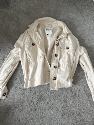 Beige jeansjacka från Only - Snygg beige jeansjacka från Only i storlek 34. Den är lite kortare. 