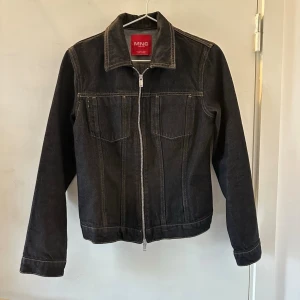 Svart jeansjacka från MNG Heritage - Snygg svart jeansjacka från Mango Heritage med kontrastsömmar och klassisk krage. Jackan har dragkedja framtill och två bröstfickor. Mycket bra skick💛