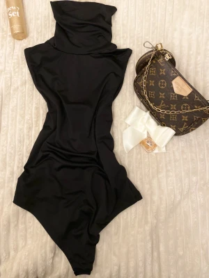 Kortärmad bodysuit   - Säljer nu den populära bodyklänning från New yorker med hög krage och ärmlös design. Tight passform som skims, den framhäver kurverna och är i stretchigt material. 🖤Den passar S/M upp till XL för den är stretchig