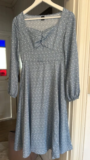 Blå blommig klänning - Söt blå klänning med vitt blommönster, aldrig använd!🥰