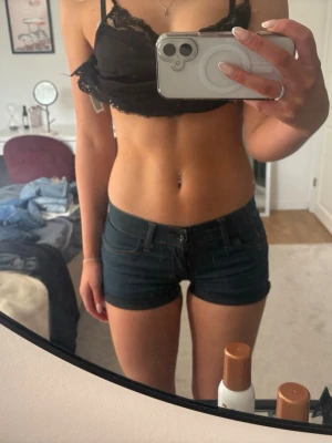 Blå denimshorts från tiger of Sweden  - Säljer ett par blå, tighta denimshorts från tiger of Sweden. Shortsen har låg midja, klassiska fickor fram och bak samt knapp och dragkedja framtill. Perfekta för sommaren och lätta att matcha med olika toppar.