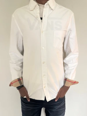 Vit skjorta från Burberry - Säljer denna feta Burberry skjorta med bröstficka. Skjortan har det kända burberry mönstret längst ner på armen. Skjortan är nästan aldrig använd, har heller inga defekter. 