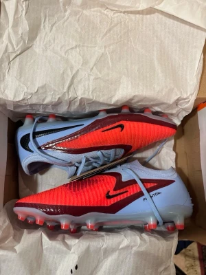 🔥 Nike Phantom 6 Elite AG-PRO “Scary Good” – Strl 44 – Nästan nya - Säljer ett par Nike Phantom 6 Elite Low Cut AG-PRO “Scary Good” i storlek 44.  ✔ Använda endast 1 gång (en kort träning) ✔ Inga skador ✔ Mycket bra skick ✔ AG-PRO sula (för konstgräs) ✔ Nypris ca 2 800–3 000 kr  Säljes pga fel storlek.  Skorna är rengjorda och redo att användas direkt. Perfekta för dig som vill ha toppmodell till bättre pris.  💰 Pris: 2 100 kr (kan diskuteras vid snabb affär)  Skickas snabbt och packas noggrant 📦 Hör av dig vid frågor! 