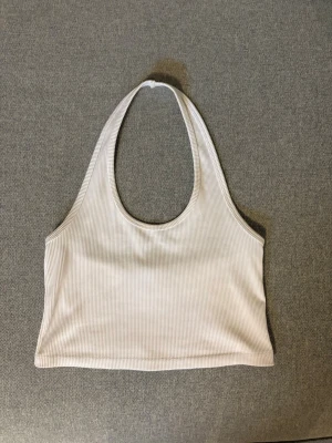 Ribbad beige halterneck linnetopp - Snygg ribbad, vit halterneck. Toppen är croppad. Storlek M och fint skick!🤗