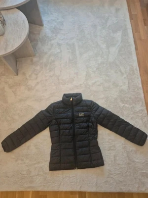 Svart pufferjacka från EA7 Emporio Armani - Snygg svart pufferjacka från EA7 Emporio i storlek 36. Jackan är i mycket bra skick.