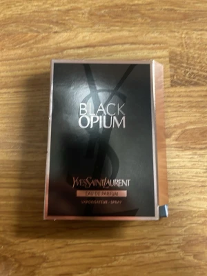Yves Saint Laurent Black Opium EdP - Black Opium Eau de Parfum från Yves Saint Laurent. Parfymen kommer i en elegant svart och roséguldig kartong och flaskan är liten, cylinderformad och genomskinlig med svart lock. Perfekt för dig som gillar lyxiga och moderna dofter.
