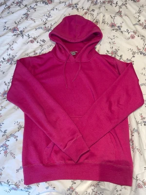 Stark rosa hoodie med huva - Säljer en snygg mörkrosa hoodie med huva och dragsnören. Jag säljer den då den är för liten för mig men gillar den fortfarande eftersom den e skön och simpel. Den är i storleken M men jag skulle säga att den är mer S (om man vill ha den liiite oversized) Den har använts ett par gånger men har inget märkbart slitage eller skador 💖