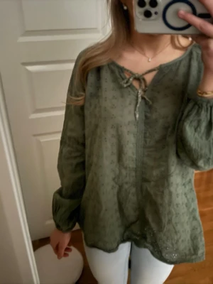 Grön blus med knyt och broderi - Snygg grön blus, väldigt bra skick, storlek M/L.