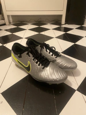 Nike Tiempo Legend 8 silver fotbollsskor - Snygga Nike Tiempo Legend 8 fotbollsskor i silver med svarta och neongula detaljer. Perfekta för dig som vill sticka ut på planen med stilrena och moderna skor. (Pris när jag köpte: nya 3500kr från Nike hemsida) pris kan diskuteras!!!