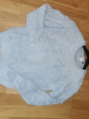 Snygg ljusblå fluffig stickad tröja - Supermjuk och fluffig ljusblå stickad tröja. Tröjan har rund halsringning och långa ärmar. Perfekt för dig som gillar en cozy och trendig look med extra fluffig känsla. Är i fint använt skick 