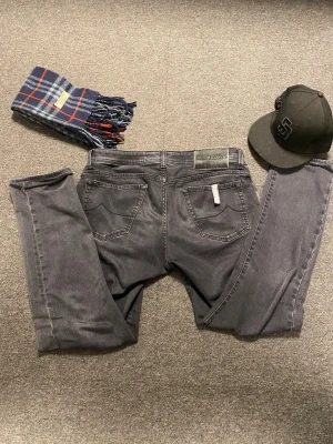 Grå jeans från Jacob Cohen - Snygga grå jeans från Jacob Cohen med klassisk femficksmodell och raka ben. Jeansen har en diskret logotyp på bakfickan och patch i läder bak i midjan. Tillverkade i mjukt denimtyg som ger en skön känsla och stilren look.