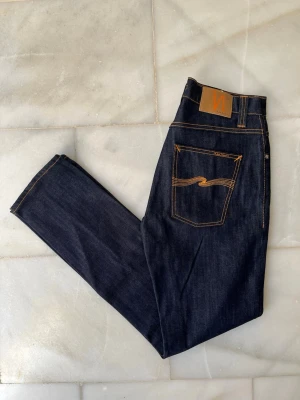 Mörkblå jeans från Nudie Jeans - Snygga mörkblå Nudie Jeans Grim Tim. De är helt nya och ALDRIG använda!                                  ——————————————————————————                                                          📐| Storlek: 32-32                                                  👖| Märke: Nudie Jeans                                         🔎 | Skick: Nytt skick                                              💵 | Ny Pris: 1699kr                                                 ✍🏻 | Skriv om du har några frågor 