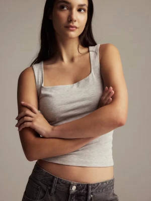 Gina Trico linne - Säljer en ljusgrå linnetopp med breda axelband och fyrkantig halsringning. Toppen är ärmlös och har en slim passform som framhäver siluetten. Använd fåtal gånger.