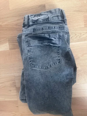 Grå tvättade utsvängda  jeans - Skulle säga i längd 152 och midja 158 Säljer ett par grå tvättade jeans med raka ben och klassisk femficksmodell. Jeansen har normalhög midja och snygga slitningar för en avslappnad look. Materialet är mjukt denim som sitter skönt på kroppen. Perfekta till en cool vardagsstil.