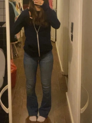 Blå bootcut jeans i stretch - Säljer ett par klassiska blå bootcut jeans med lätt utsvängda ben. Jeansen har en snygg tvätt och sitter tajt över låren för en schysst siluett. Tillverkade i stretchigt denim för extra komfort. Perfekta till sneakers eller boots!