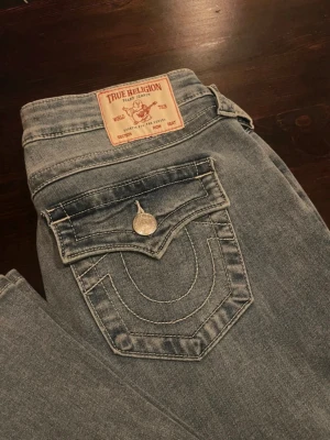 Lågmidjade bootcut jeans i ljusblå från True Religion - Säljer ett par helt nya oanvända ljusblåa jeans från True Religion i storlek W27, jeansen är lågmidjade och bootcut. Säljer dem då jag av misstag köpte fel storlek💗Jag kan även tänka mig att byta dem mot ett par likadana jeans som är i storlek W25 och i nyskick! Kontakta mig om ni vill ha fler bilder eller undrar över något💗