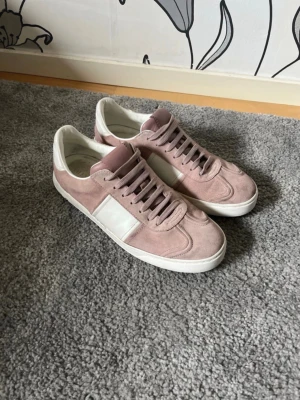 Valentino flycrew - Snygga vita sneakers med rosa detaljer på tungan och hälen. Skorna har en klassisk låg profil och är tillverkade i ett slätt material som ger en clean look. Perfekta för dig som gillar stilrena och trendiga sneakers.