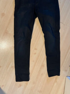 Svarta skinny jeans från G-Star - Säljer ett par svarta skinny jeans från G-Star med klassisk femficksdesign och diskret logga vid fickan. Jeansen har smal passform och är tillverkade i ett stretchigt denimtyg som sitter snyggt och bekvämt. Perfekta till en streetwear-look.