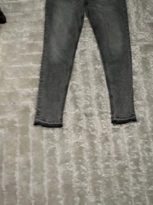 Grå flared fit jeans - Snygga grå slim fit jeans med tvättad look och smala ben. Klassisk femficksmodell och normal midja. Perfekta till en avslappnad streetstyle eller att matcha med en hoodie.