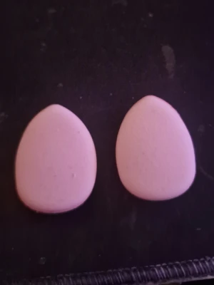 Rosa makeupsvampar droppformade - Två ljusrosa beautyblenders i droppform, perfekta för att applicera foundation eller concealer. Svamparna har en slät sida och en sida med ett snitt för bättre grepp. Tillverkade i mjukt skumgummimaterial för en jämn finish.