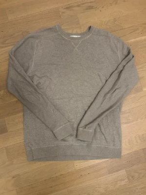 Beige tröja från Kappahl - En stilren beige tröja från Kappahl i storlek M. Tröjan har rund halsringning, långa ärmar och ribbade muddar vid ärmslut och nederkant. Perfekt basplagg för en enkel och clean look.