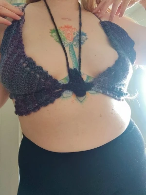 Handvirkad mörklila bralette i form av fjäril 🦋 - Unik handvirkad bralette i mörklila nyanser. Modellen är öppen framtill med breda axelband och knyt i nacken. Akrylgarn. Själva fjäril är ungefär 36cm bred