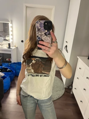 Vit t-shirt med tryck och text - Vit t-shirt med korta ärmar och ett stort tryck framtill som föreställer groot med texten 'COME TO THE CUTE SIDE'. T-shirten har en avslappnad passform och är gjord i mjuk bomull, perfekt för en chill och trendig look.