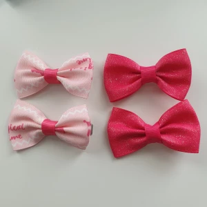 4st rosa rosetter hårspännen, nya  - Söta rosett hårspännen  Färg: 2 är ljusrosa med text. 2st är rosa med glitter  Antal: 4st Skick: ny/oanvänd, Storlek: rosett ca 6cm. Spännet ca 4,5cm