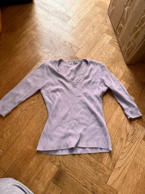 Ljuslila ribbad topp från Weiye  - Säljer en ljuslila ribbad topp från Weiye med v-ringning och trekvartsärm. Toppen har en slim passform, perfekt för en chill och stilren look.Skriv gärna för mått! 💕