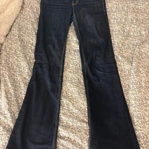 Mörkblå bootcut jeans cheap Monday  - Säljer ett par mörkblå bootcut jeans med snygga kontrastsömmar och klassisk femficksdesign. Jeansen har hög midja och utsvängda ben, perfekta för en trendig och avslappnad look. Materialet är kraftig denim som ger en schysst passform. Storlek 25/32