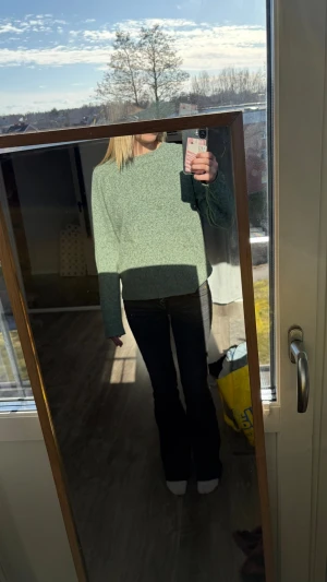 Grön stickad tröja med lös passform - Mysig grön stickad tröja med rak och lös passform. Tröjan har långa ärmar och rund halsringning. Perfekt för lager på lager och enkel att styla till jeans eller kjol. Materialet ser mjukt och bekvämt ut, perfekt för kyligare dagar.