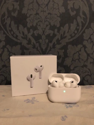 Apple AirPods Pro trådlösa hörlurar - Säljer ett par vita Apple AirPods Pro med laddningsetui. Hörlurarna har in-ear design, silikonproppar och stilren form. Perfekta för dig som vill ha brusreducering och smidig anslutning till iPhone eller andra Apple-enheter.