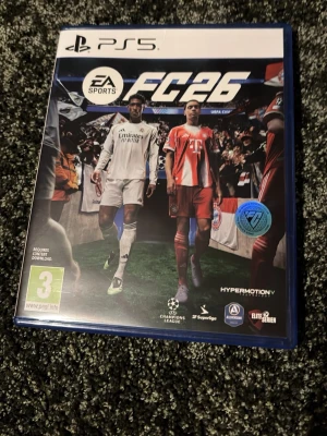 EA Sports FC 24 till PS5 - Säljer spelet EA Sports FC 24 till PlayStation 5. Omslaget är blått med två fotbollsspelare i vita och röda matchställ. Spelet är i fysisk utgåva och har PEGI 3-märkning. Perfekt för dig som gillar fotbollsspel och vill spela de största ligorna.