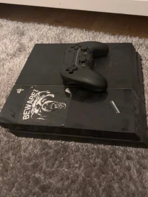 PlayStation 4 - Säljer ett svart PlayStation 4 Konsolen har en stilren, fyrkantig design och medföljer gör en svart handkontroll. Perfekt för gaming och filmkvällar med vänner.