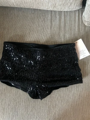 Svarta paljettshorts - Skitsnygga glittriga korta svarta shorts täckta med paljetter. Helt oanvända