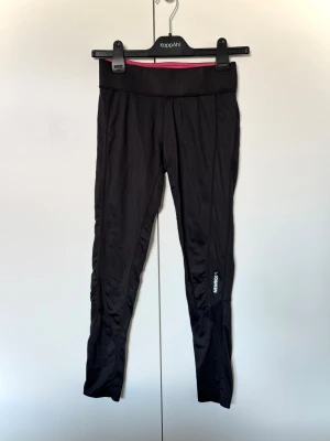 Träningstights storlek S från Newbody - Leggings som passar för träning i strl S från Newbody. Längden är relativt kort och passar någon som är ca 155-160 cm. Slitage i form av att texten på benet delvis har försvunnit. I övrigt bra skick.
