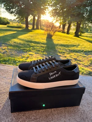 Saint Laurent skor svarta stl 43 - Snygga svarta sneakers från Saint Laurent med vit sula och märkets logga i vitt på sidan. Skorna har klassisk snörning och en stilren design som passar perfekt för en trendig look. Endast testade men tyvärr för små.