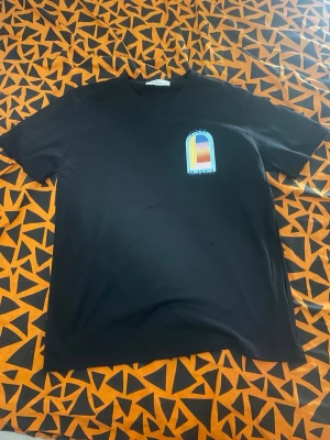 Svart t-shirt Casablanca - Svart t-shirt från Casablanca med färgglatt tryck av ett fönster och texten 'Casa Blanca' på både bröstet och ryggen. Klassisk passform och rund halsringning. Perfekt för dig som gillar stilrena plagg med en twist. Pris kan diskuteras 
