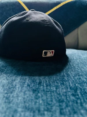 Boston Red Sox svart keps MLB - Svart keps från New Era med Boston Red Sox logga i rött och vitt framtill samt MLB-logga baktill. Klassisk böjd skärm och broderade ventilationshål. Perfekt accessoar för dig som gillar sportig stil och streetwear.