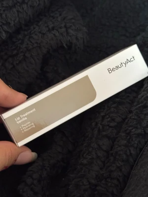 BeautyAct Lip Treatment Vanilla - Lip Treatment Vanilla från BeautyAct är ett läppbalsam med peptider som återfuktar och reparerar läpparna. Kommer i en stilren, rektangulär förpackning i vitt och beige. Doft av vanilj och passar perfekt för dig som vill ha mjuka och återfuktade läppar.