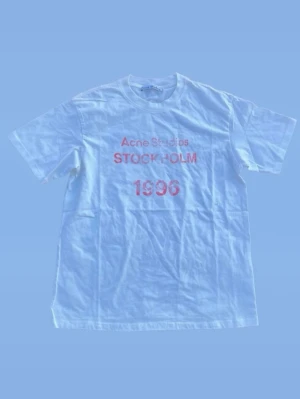 Vit Acne Studios T shirt  - Säljer denna Acne studios t-shirten i färgen  vit/rosa. Den är i mycket fint skick (9/10) och utan defekter. Storlek S men skulle säga att den sitter mer som M och passar unisex.   Pris kan diskuteras vid snabb och smidig affär.  Hör gärna av dig om du har några frågor eller funderingar 🙌