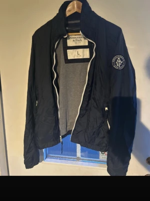 Marinblå vindjacka Abercrombie & Fitch - En vår/höst jacka från Abercrombie & fitch Storlek L men passar M också Marinblå  Skriv vid frågor, priset är ej hugget i sten!