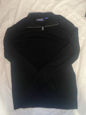 quarter zip svart - Snygg svart quarter zip från Jack & Jones med halv dragkedja vid halsen. Väldigt mjuk material.