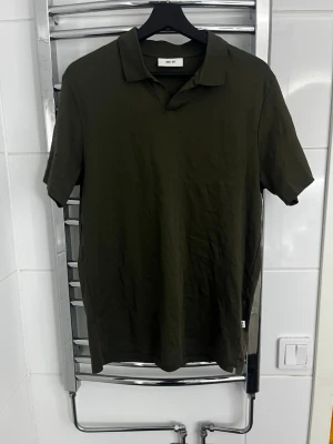 piké NN.07 - Säljer en stilren mörkgrön piké t-shirt från NN.07. T-shirten har klassisk krage och korta ärmar, perfekt för en clean och avslappnad look. Tillverkad i mjuk bomull som känns skön mot huden. Enkel att matcha med jeans eller shorts.